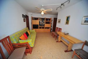 sala de estar con sofá, mesa y sillas en Veracruz Orange Costa, en Benicàssim