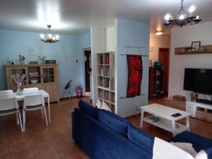 - un salon avec un canapé bleu et une table dans l'établissement Quinta do Bosque, à Vagos