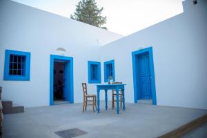 una casa azul con mesa y sillas azules en The Water Mill Cottage en Lagoúdi Zía