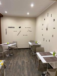 a restaurant with tables and chairs and a wall with clocks at Leus Appartment in Reggio Calabria