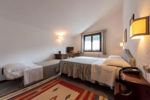 - une chambre avec 2 lits et une fenêtre dans l'établissement Hotel Triolet, à Courmayeur