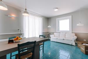 uma sala de estar com uma mesa e um sofá branco em Lamare cucina e dimore em Polignano a Mare