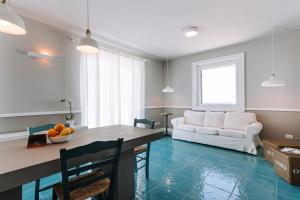 a living room with a table and a white couch at Lamare cucina e dimore in Polignano a Mare