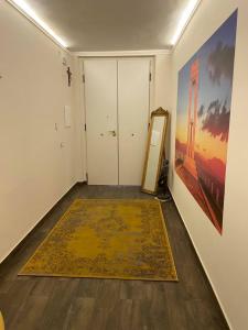 um corredor com um tapete no chão e um espelho em Leus Appartment em Reggio di Calabria
