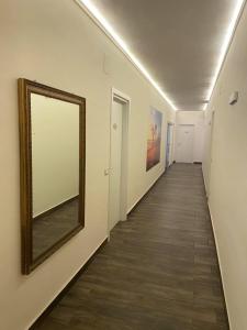 um longo corredor com um espelho na parede em Leus Appartment em Reggio di Calabria