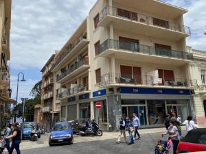 un edificio in una strada di città con persone e auto di Leus Appartment a Reggio di Calabria