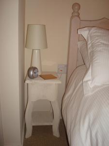 a bedside table with a lamp next to a bed at Riverside Apartment in Launceston