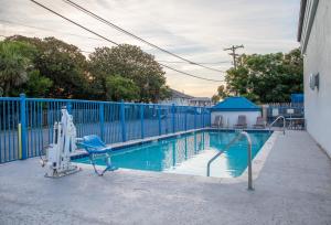 a swimming pool with a blue fence and a blue pool at Sandcastle Inn in Tybee Island