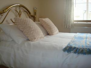 Una cama blanca con dos almohadas encima. en Riverside Apartment, en Launceston