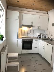 a kitchen with white cabinets and a stove top oven at Apartment in Bad Schwartau in Bad Schwartau