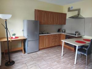 een keuken met een roestvrijstalen koelkast en een tafel bij Apartament we Wrzeszczu in Gdańsk