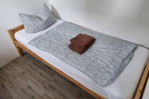 Una cama con una manta gris y almohadas. en Ferienwohnung/Monteurwohnung Alte Garage en Weimar