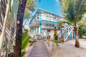 a building on the beach with a palm tree at Condo #25 @ Beachside Villas in Placencia