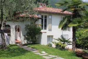 a white house with a palm tree in the yard at Villa Serendipità in Gardone Riviera