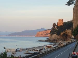a road next to the water with a castle on a cliff at SEAHORSEROOM in Finale Ligure