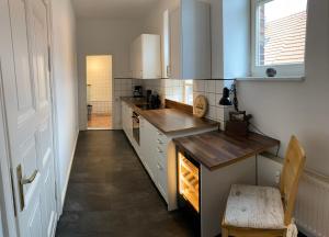 a kitchen with white cabinets and a wooden counter top at Ferienwohnung Bress OG in Ueckermünde