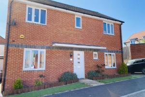 a red brick house with a white door at Spacious home for contractors and families in Sherborne Saint John