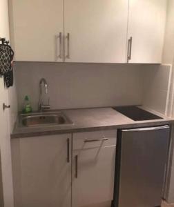 a kitchen with white cabinets and a sink at Studio de 35m2 à 5 minutes de la Gare de Lyon in Paris