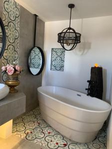 La salle de bains est pourvue d'une grande baignoire blanche et d'un lavabo. dans l'établissement Casa Martha hotel boutique, à Tequisquiapan