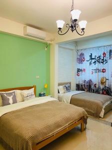 a bedroom with two beds and a chinese painting on the wall at Third Sisters Home in Jinning