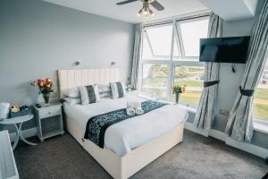 a bedroom with a bed and a window at OYO Minerva Guesthouse in Newquay