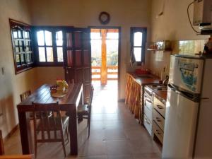 a kitchen with a refrigerator and a table in it at cabaña La Retama in Villa Yacanto