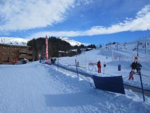 a snow covered ski slope with people skiing on it at La Dent Du Villard in Courchevel
