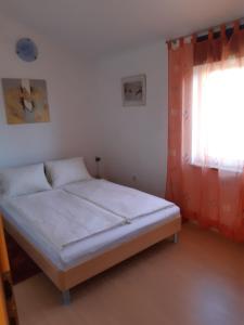 Bett in einem Zimmer mit Fenster und Bettrahmen in der Unterkunft Apartmani Franka in Rovinjsko Selo