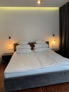 a large bed with white sheets and pillows on it at Wil-Art Jurata in Jurata