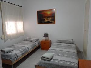 a room with two beds and a picture on the wall at Piso Grande Mercado Central Alicante in Alicante