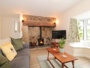 a living room with a couch and a fireplace at Ammerham Farm Cottage in Chard