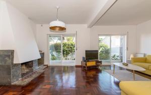 a living room with a fireplace and a yellow couch at Lovely villa with 3 bedrooms and swimming pool in Cascais