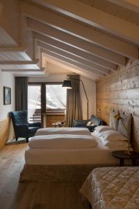 Habitación de hotel con 2 camas y ventana grande. en Mountain Home Villa Anna en Selva di Val Gardena