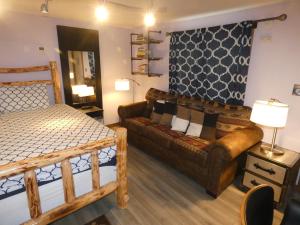 um quarto com um sofá, uma cama e um sofá em Yellowstone Motel - Adults Only - All rooms have kitchens em West Yellowstone