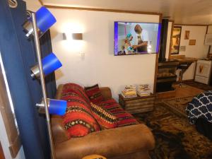 uma sala de estar com um sofá e uma televisão em Yellowstone Motel - Adults Only - All rooms have kitchens em West Yellowstone