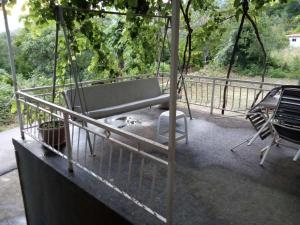 a porch swing with a bench and a chair at Smještaj Elena in Budva