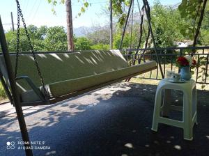 a green swing with a small table in front of it at Smještaj Elena in Budva