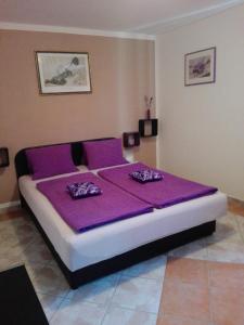 ein Schlafzimmer mit einem lila Bett mit lila Bettwäsche in der Unterkunft Apartmani Franka in Rovinjsko Selo