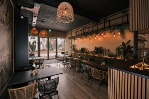 a restaurant with tables and chairs and a bar at Stadshotel Weert in Weert