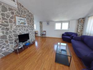 a living room with a blue couch and a stone wall at Apartment Jure in Primošten