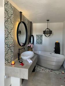een badkamer met een bad, een wastafel en een spiegel bij Casa Martha hotel boutique in Tequisquiapan