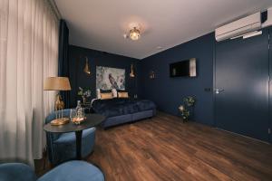 a blue bedroom with a bed and a table at Stadshotel Weert in Weert