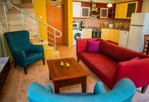 a living room with a couch and two chairs and a table at Dores Residence in Turunç