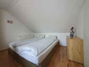 sypialnia z łóżkiem i drewnianą szafką w obiekcie Nyíl Apartman wellnes w Debreczynie