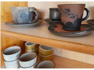 un estante con tazas y platos. en Monzen House Dormitory type- Vacation STAY 49374v, en Kasama
