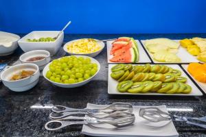 a table with plates of food and bowls of fruit at Vale d'El Rei Hotel & Villas in Carvoeiro