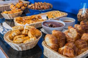 a table with baskets of bread and pastries on it at Vale d'El Rei Hotel & Villas in Carvoeiro
