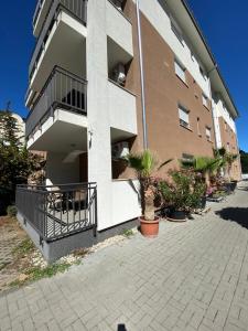 an apartment building with a balcony and potted plants at Andi Apartman in Siófok