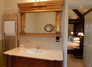 a bathroom with a sink and a mirror and a bed at Westgate Manor in Westgate