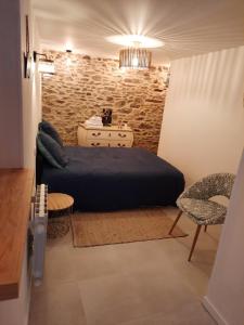 a bedroom with a bed and a stone wall at Granville plage normandie mont saint Michel in Granville